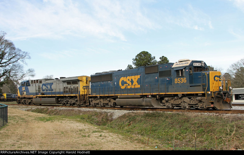 CSX 8536 & 228 are on one leg of the wye with a train passing behind it 